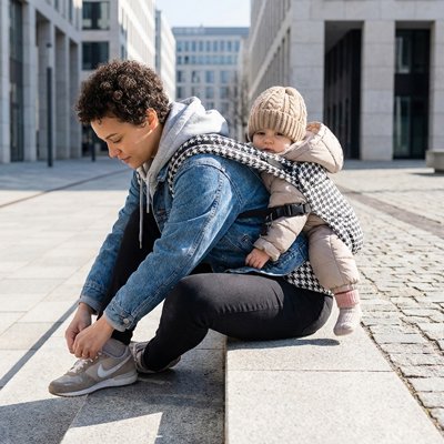 Maman Porte bebe tout en faisant ses lassets