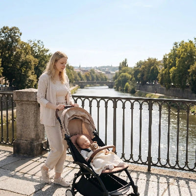 Bebe avec doudou dans la poussette traverse le pont