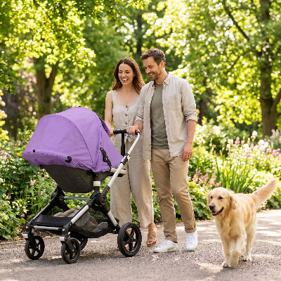 Famille heureuse promenent bebe protege avec pare soleil poussette