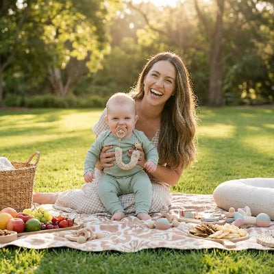 Maman attache tetine a bebe en pic nic