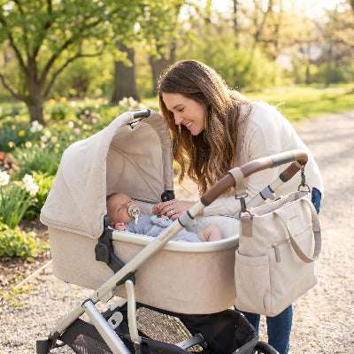 Maman avec bebe dans poussette utilisant doudou attache tetine