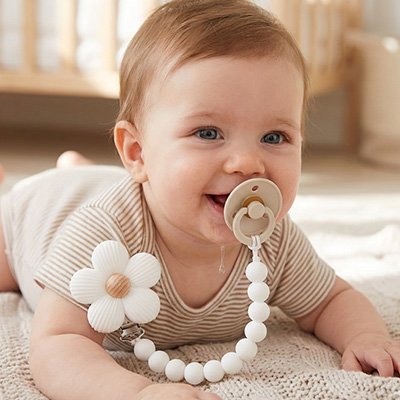 Bébé au sol heureux de Attache tetine 