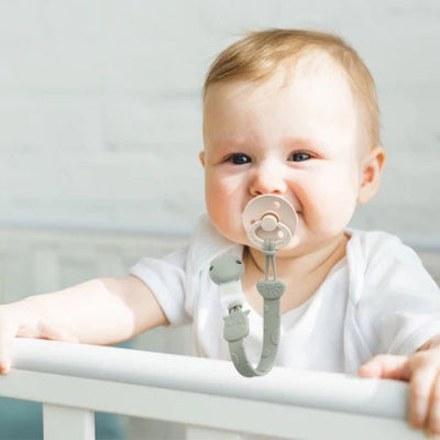 Bébé dans berceau avec Attache tetine 