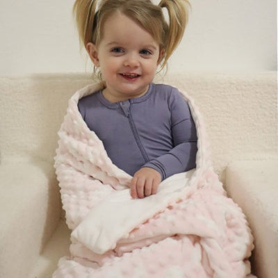 Couverture bebe assise sur le divan