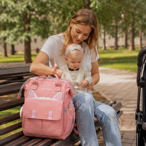 maman assise avec sac a dos a langer