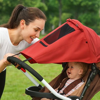 Maman regarde bébé dans fenetre Pare soleil pour poussette​